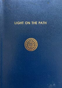 Blue book cover titled 'Light on the Path' with gold emblem and text.